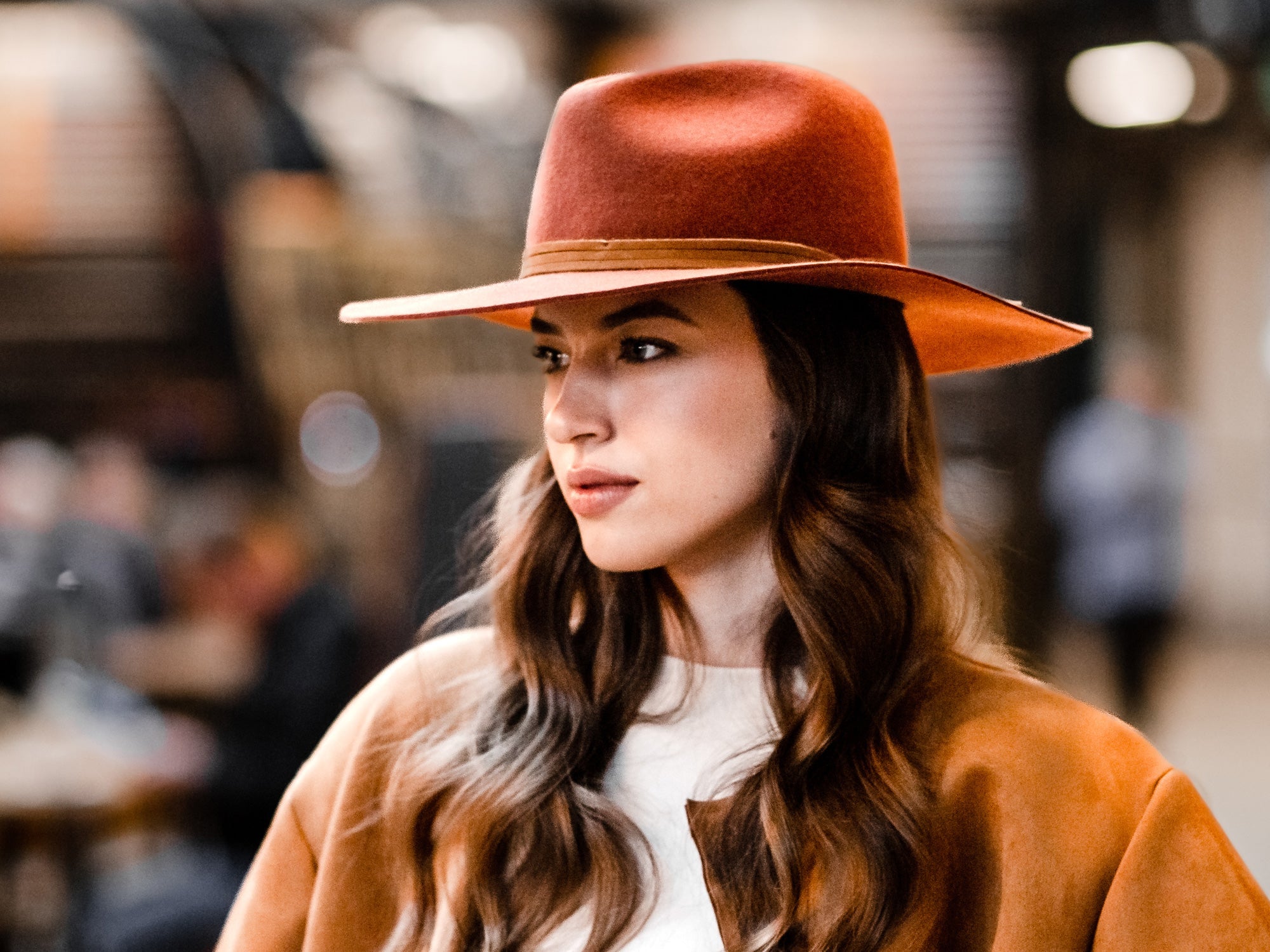 Rust orange wool felt fedora worn with wide flat brim