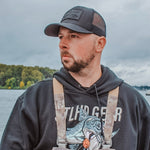 Dark trucker cap with STLHD logo patch, worn by a person outdoors