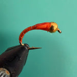 BeadHead chironomid fishing fly with burnt orange segmented body and gold bead head.