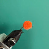 Orange fuzzy fishing lure with looped hook