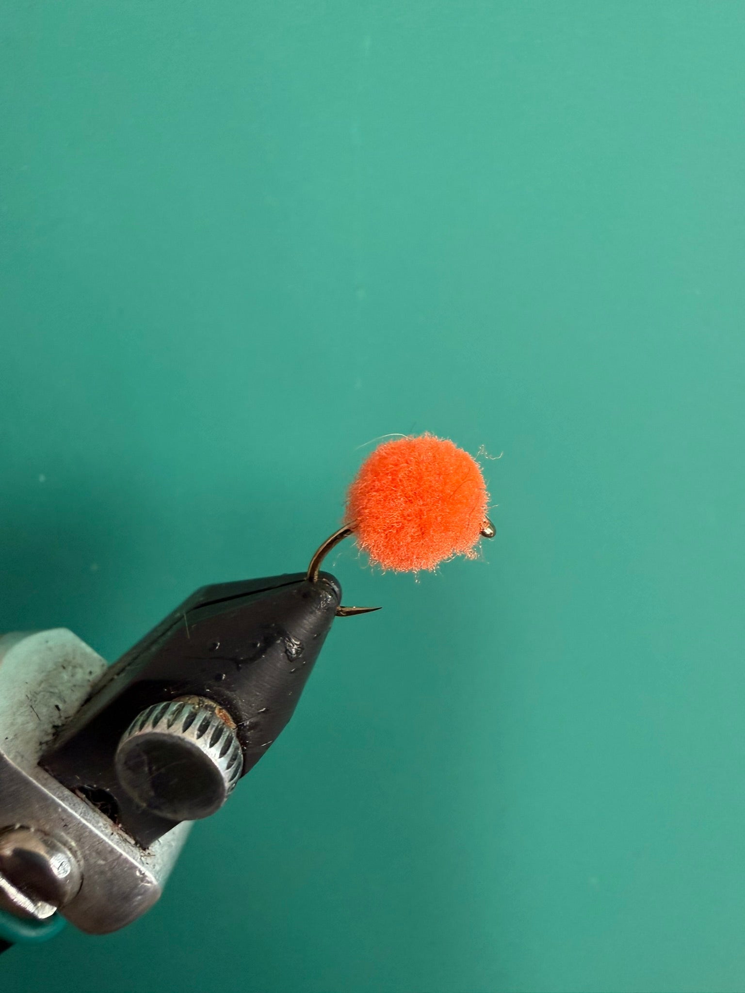 Orange fuzzy fishing lure with looped hook
