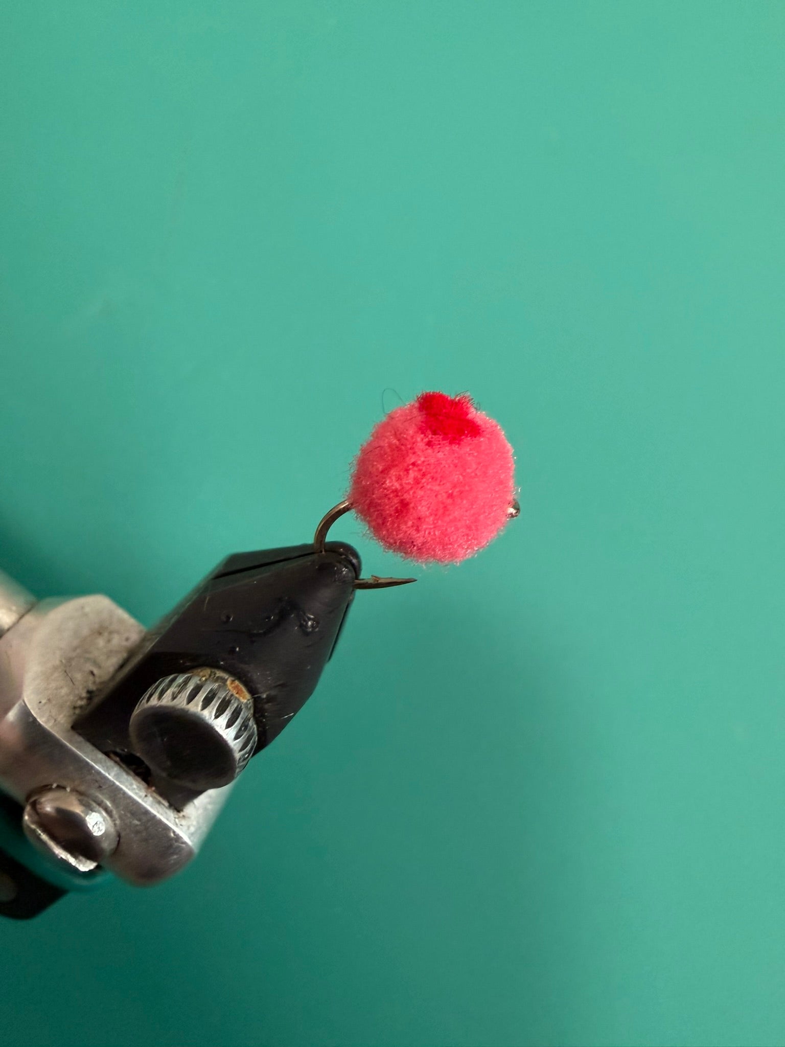 Glo Bug red dot toy with fuzzy pink pom-pom on black metal clip