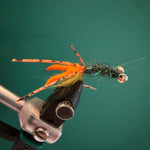 Crawfish-style fishing fly with orange body, fuzzy legs, and black wire head