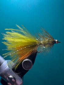Olive and orange feather fishing lure with dark hook and wing tail