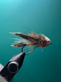 Muddler Minnow fishing lure with fuzzy gray-and-brown body and black hook