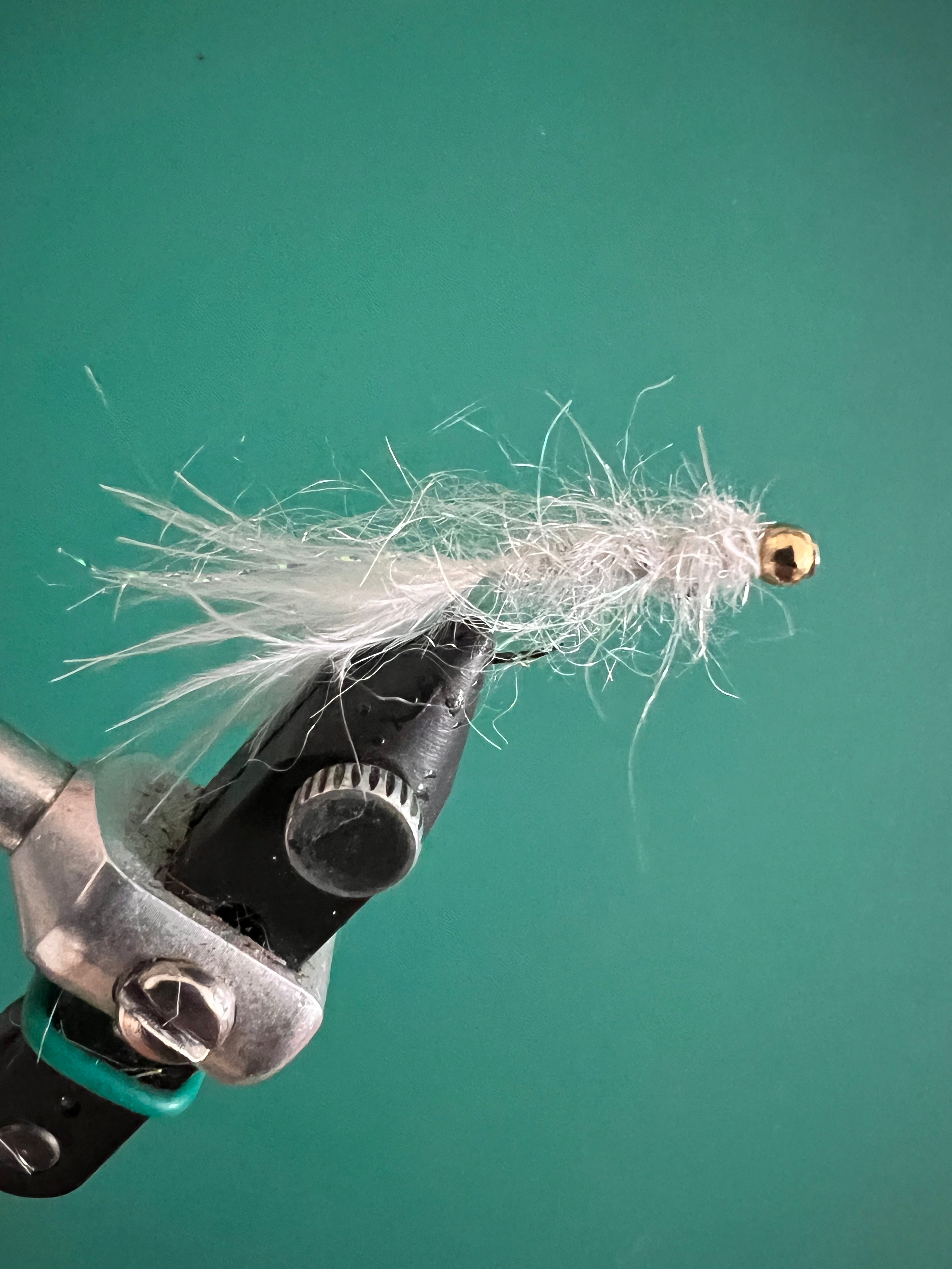 White leech fly with tungsten bead and barbless hook, gold bead and fuzzy tail