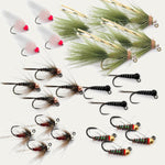 Assorted trout flies laid out, feather and foam bodies, barbed hooks, green and black.