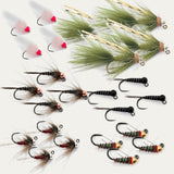 Assorted trout flies laid out, feather and foam bodies, barbed hooks, green and black.