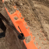 Orange recovery leash strap with black end, lying across dirt ground