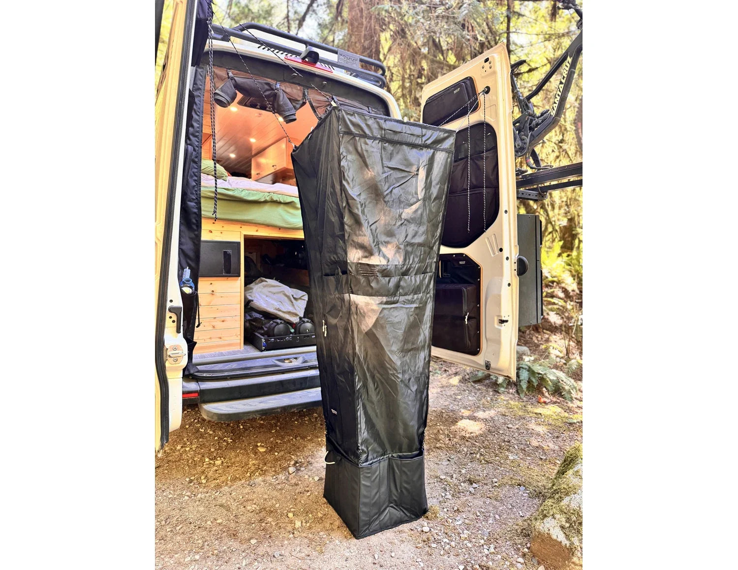 Outdoor hanging shower kit in black fabric with hanging straps and storage compartment