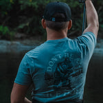 Blue T-shirt worn by model, showing back dinosaur “ICE HOLE” print
