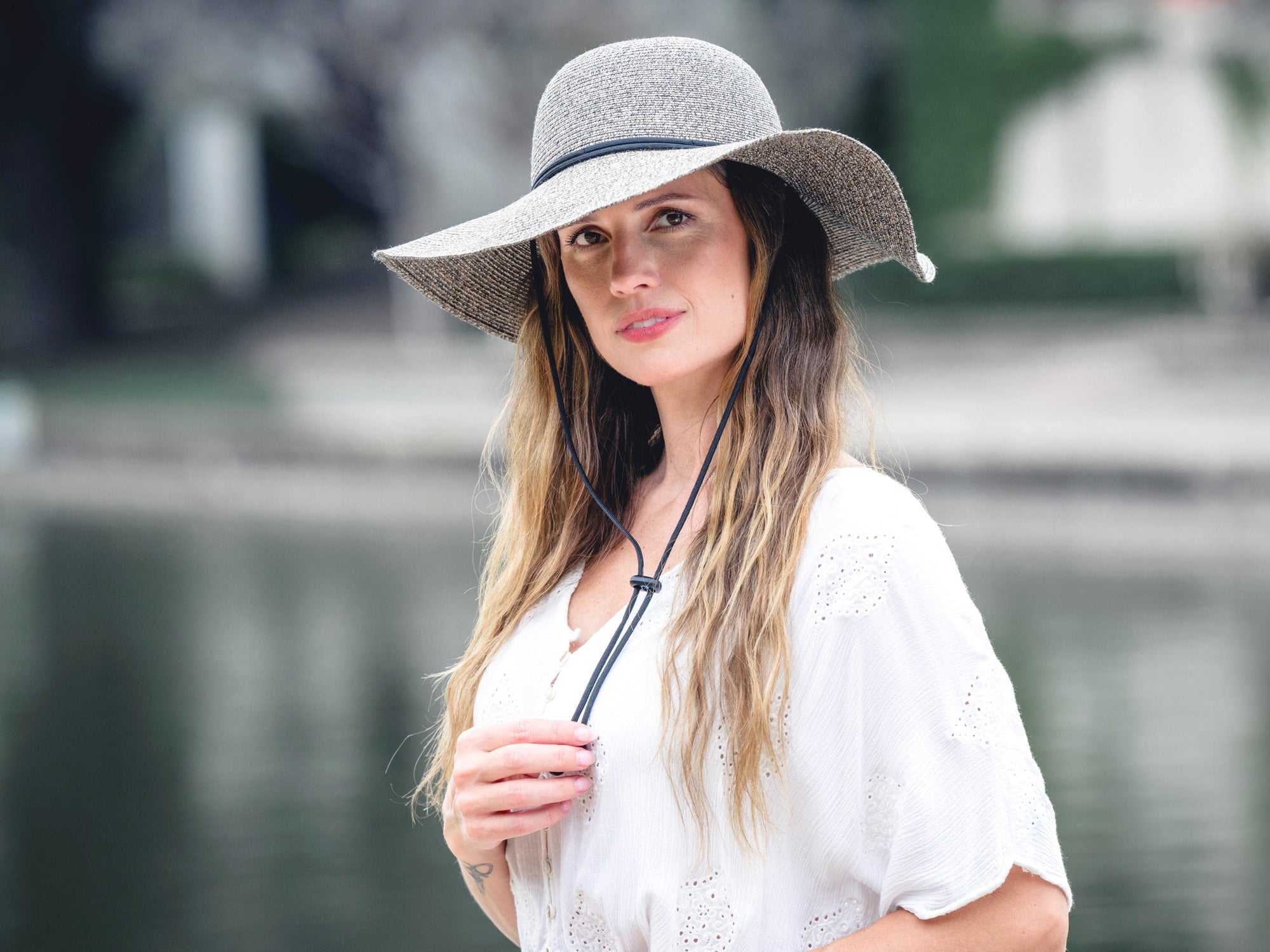 Stone poly braid wide-brim hat on model, with black band and chin cord.