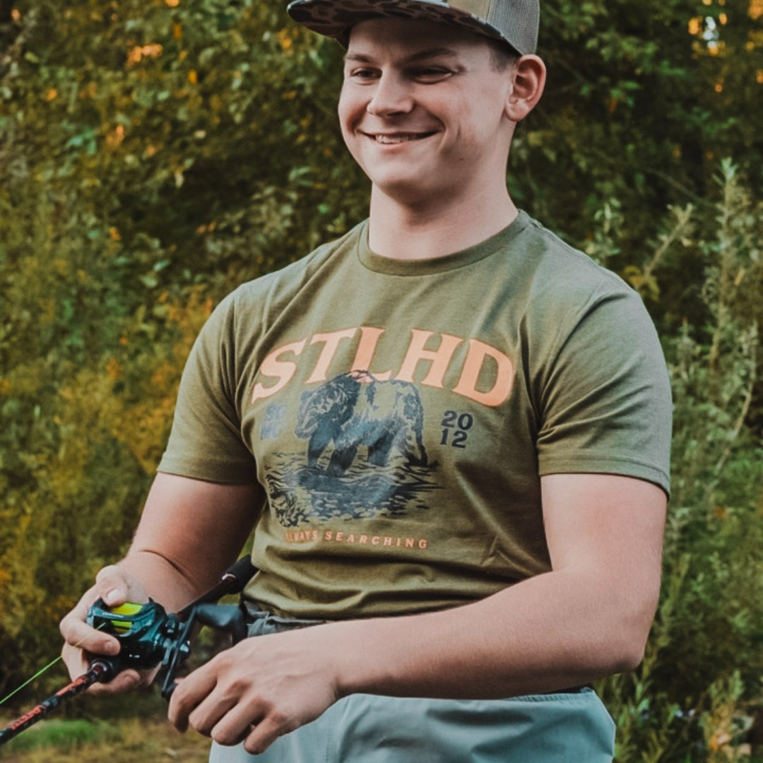 Olive STLHD grizzly bear graphic t-shirt on person outdoors