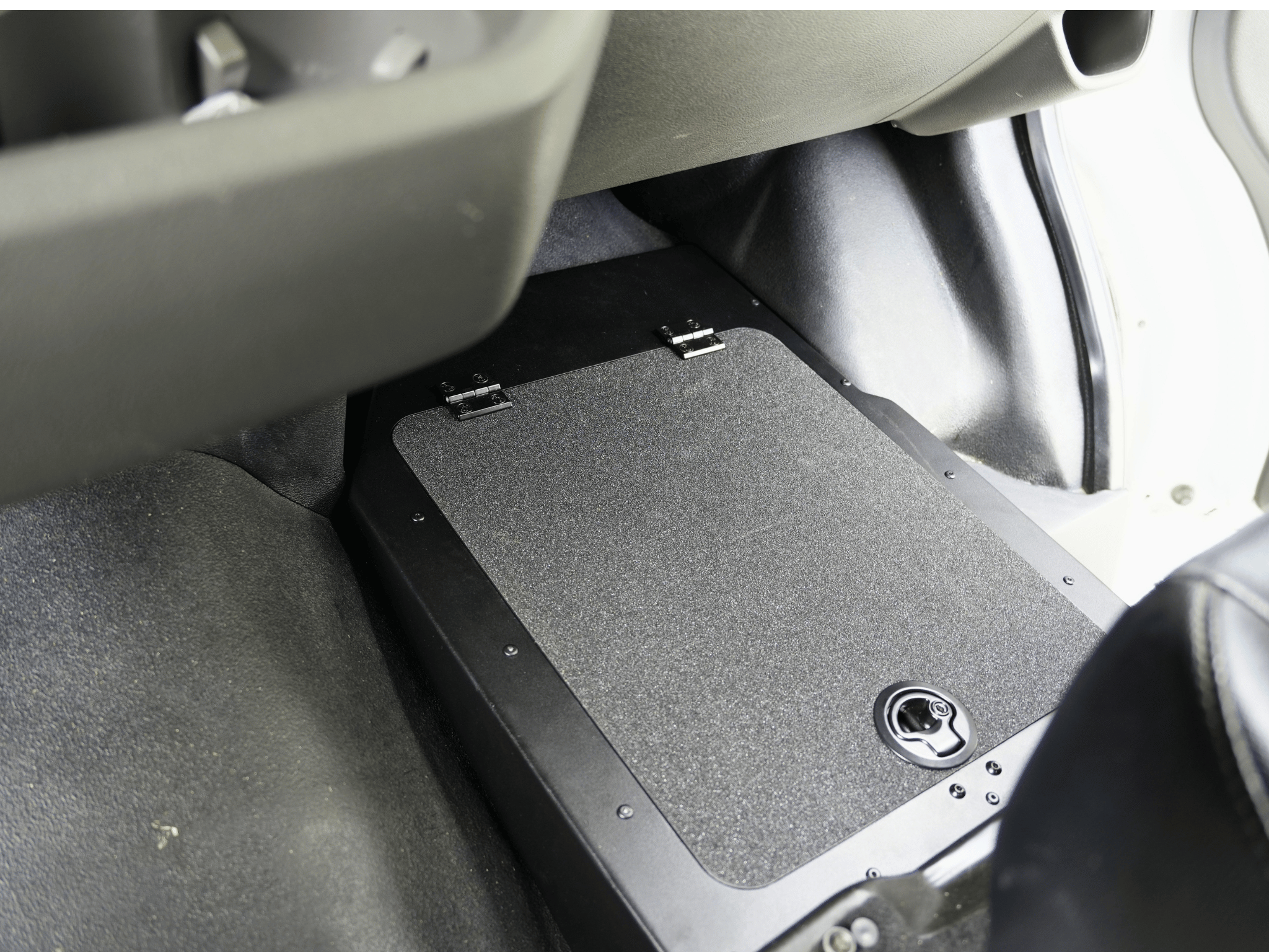 Under-seat foot platform with textured surface and latch, black base near seat