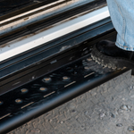 Close-up of black perforated step surface with mounting points