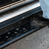 Close-up of black perforated step surface with mounting points