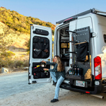 Passenger-side Atlas storage rack with pegboard panel and black organizer bags on open rear doors