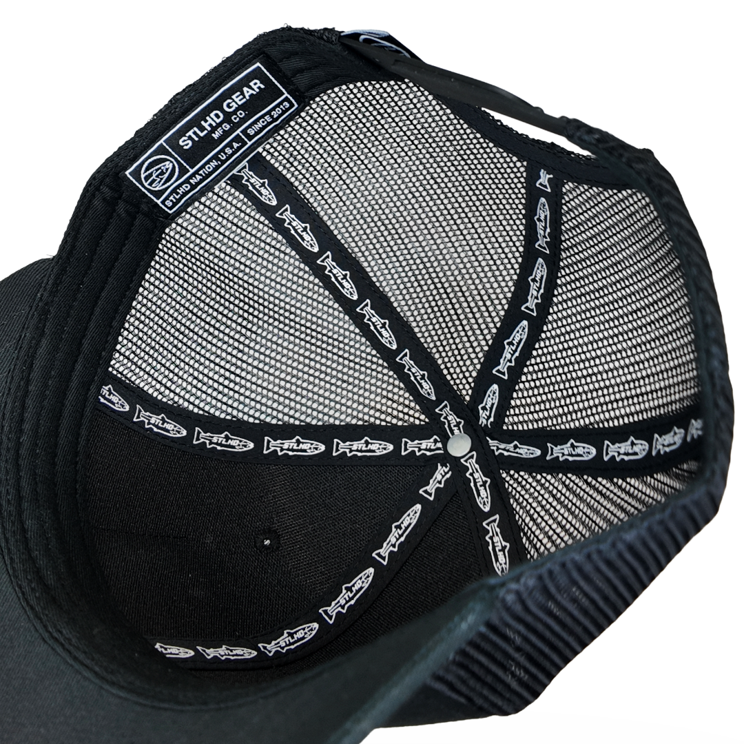 Black mesh-back trucker cap interior with stitched STLHD GEAR label