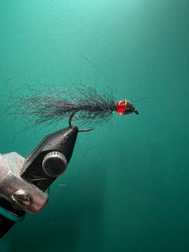 Black cone-head leech fishing fly with red lure head