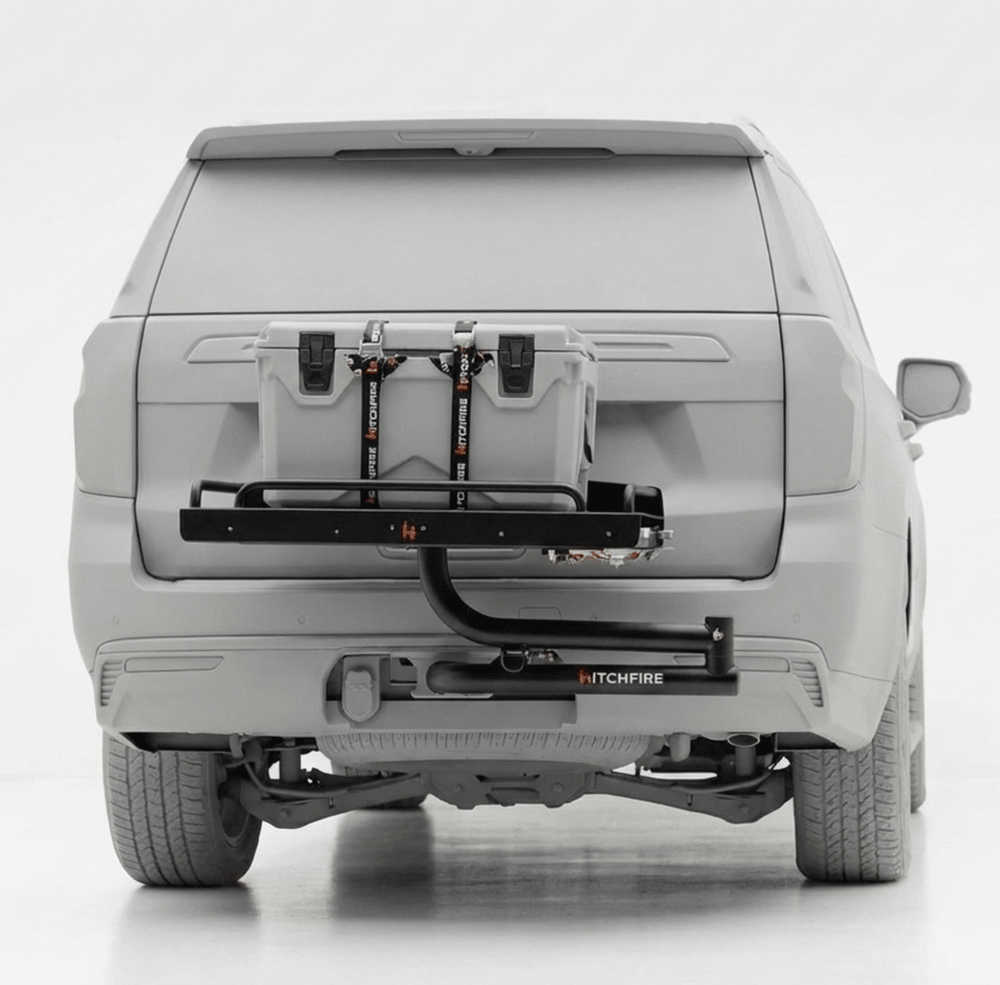 Hitch-mounted cook station with swing-out grill tray under open tailgate