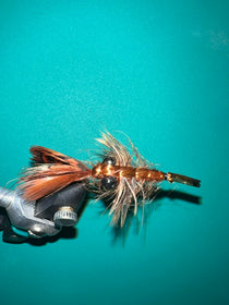 Crayfish-style fishing lure with brown body, feather tail, and black hook