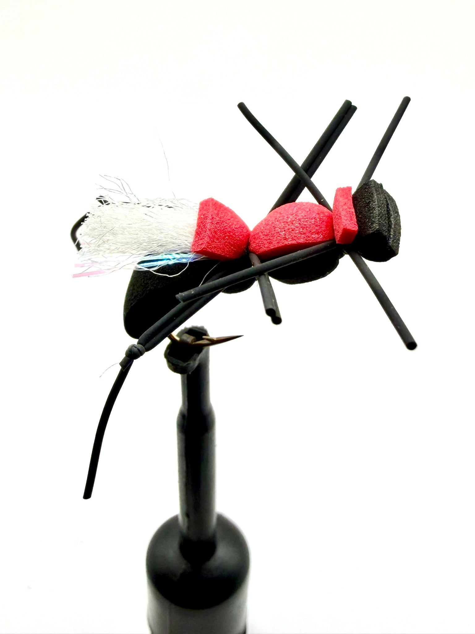 Novelty foam fly fishing lure with red foam body, white tuft, and black legs