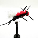 Novelty foam fly fishing lure with red foam head, black legs, and white tuft