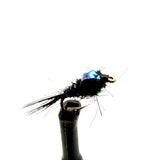Black fly nymph lure with blue wing accent and barbed hook, close-up