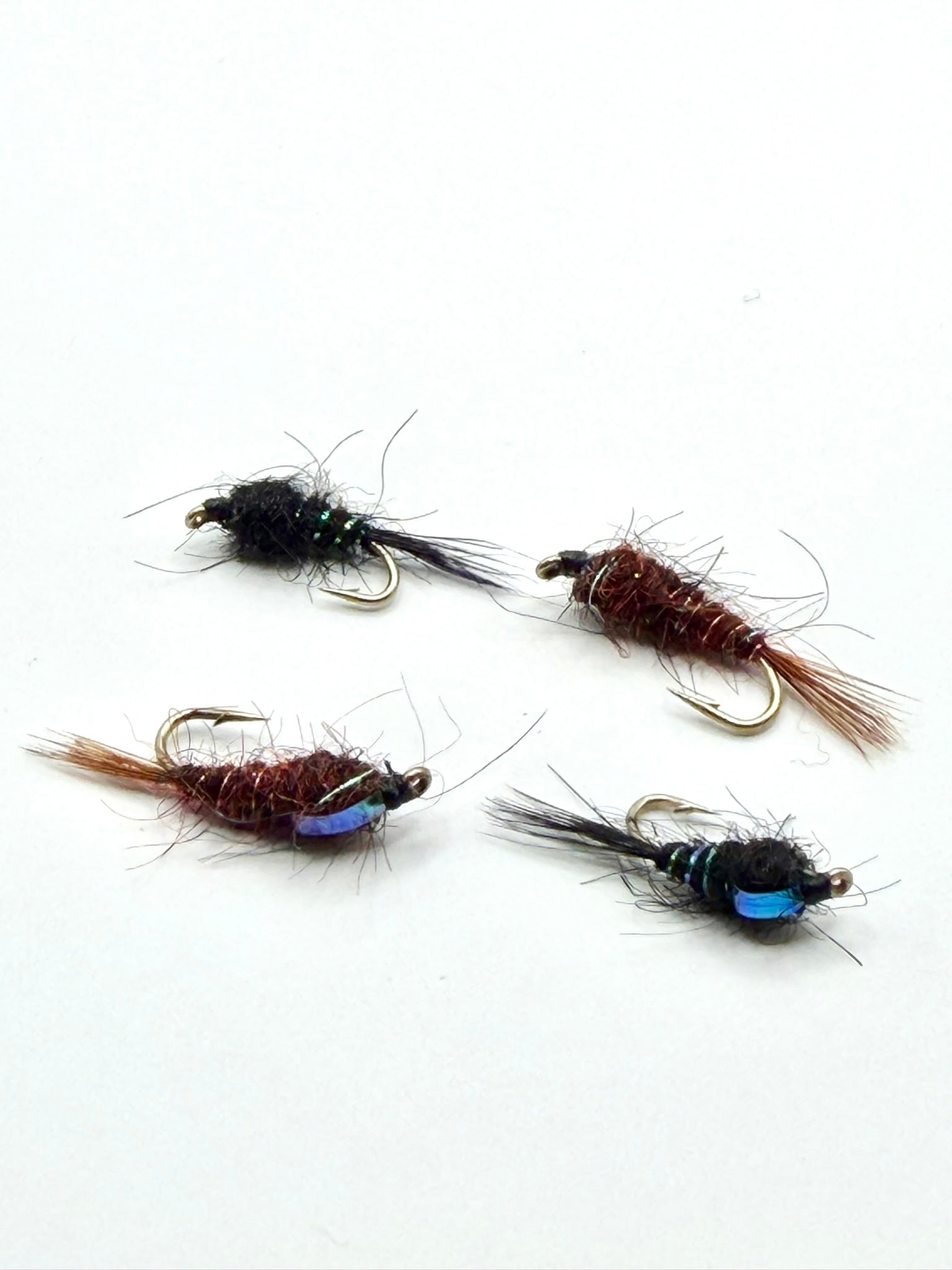 Assorted fly nymph lures with brown bodies and blue accents, barbed hooks