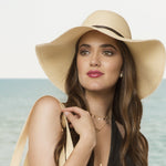 Beige paper braid floppy hat with wide brim, dark band, drawstring tie cords