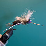 Feather streamer fly with fluffy marabou tail, tied on hook shank with thread