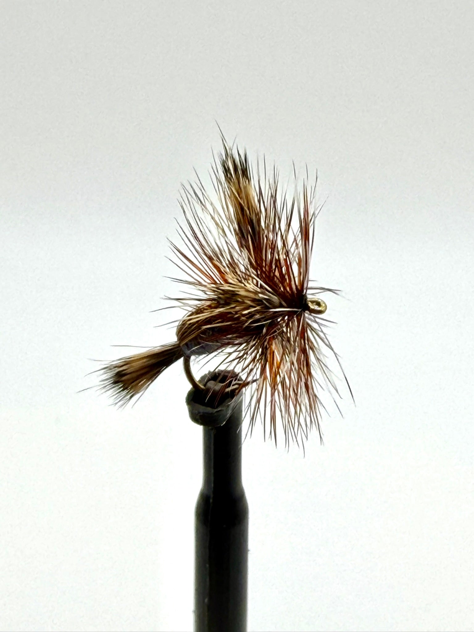 Dry fly fishing lure with brown feather hackle, tied on an eye hook