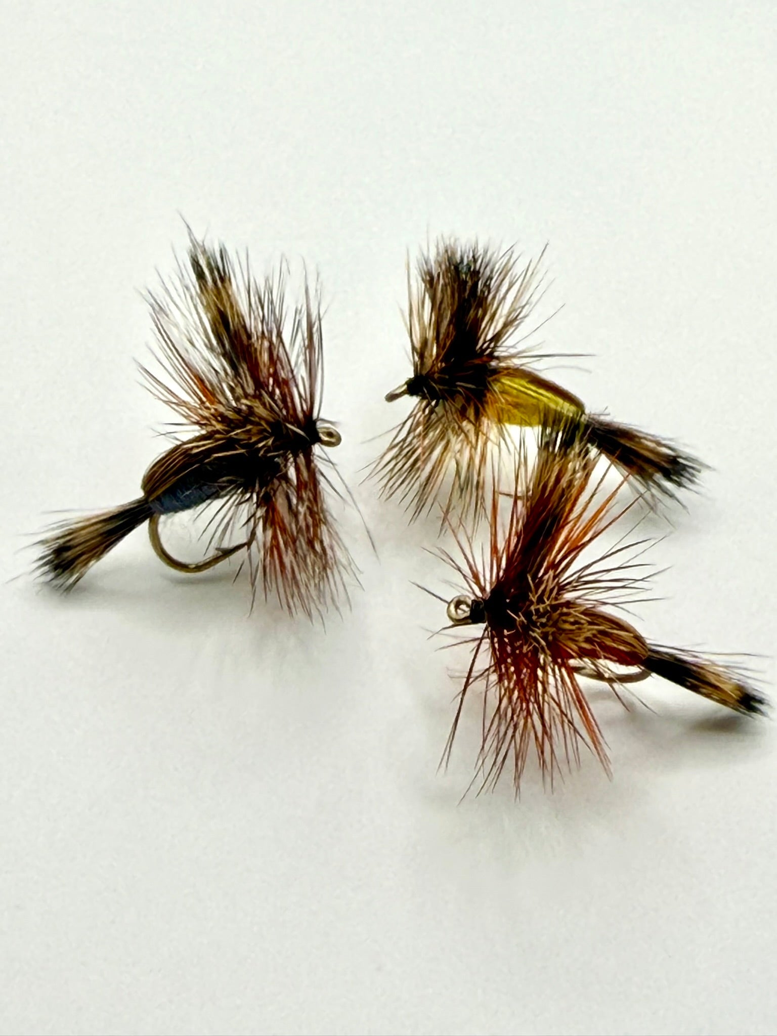 Dry fly fishing lure with orange and brown feather hackle, tied on an eye hook