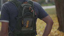 Olive green chestpack backpack with padded straps and front zip pocket, orange accents