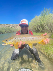 Trout kit with fly rod and reel, holding a spotted trout