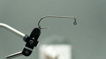 Stainless jig hook with black jig head and curved spring wire hook guard