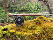Fishing rod with cork handle and fly reel, with line guides along the shaft