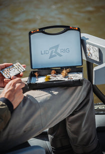 Fishing tackle box with lid open and lure clips on the tray
