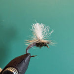 Fishing fly lure with white deer-hair body on barbed hook