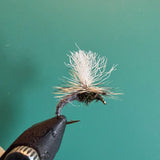 Fishing fly lure with white deer-hair body on barbed hook