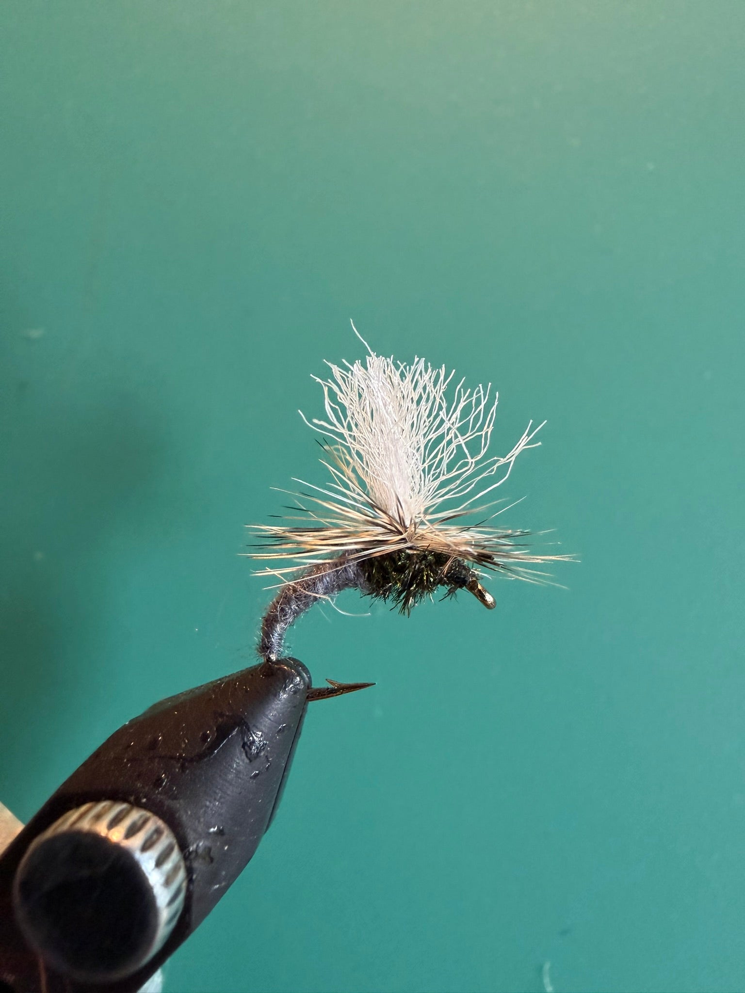 Fishing fly lure with white deer-hair body on barbed hook