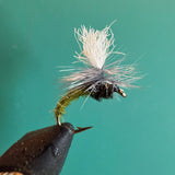 Fishing fly lure with white deer-hair body and dark thorax on barbed hook