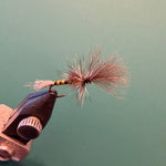 Fishing fly lure with copper hook and pink-red bristle tail