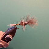 Fishing fly lure with copper hook, pink-red fuzzy tail