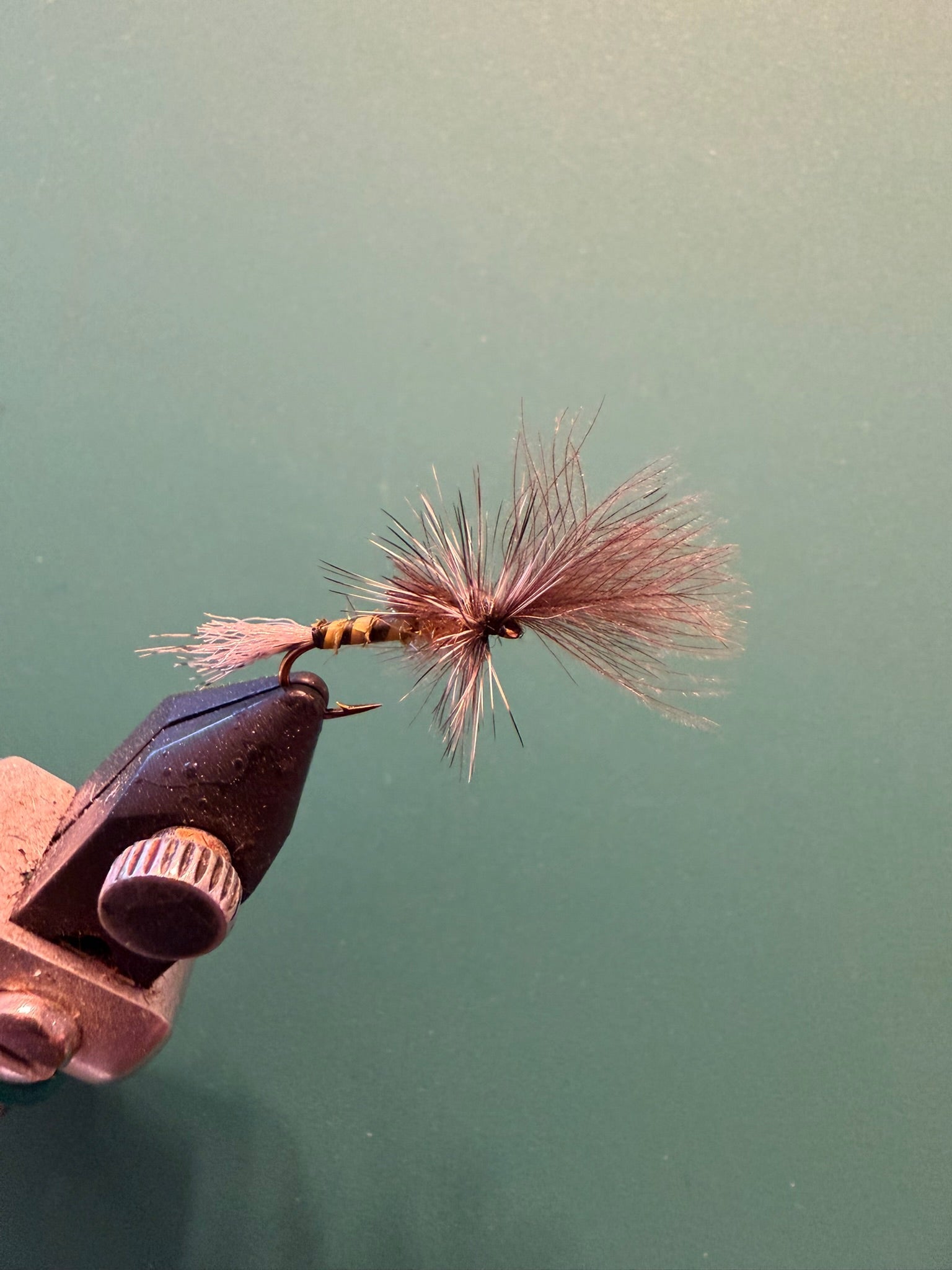 Fishing fly lure with copper hook, pink-red fuzzy tail