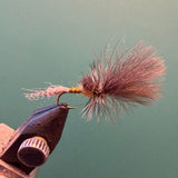 Fishing fly lure on bronze hook with coral-pink hair wing
