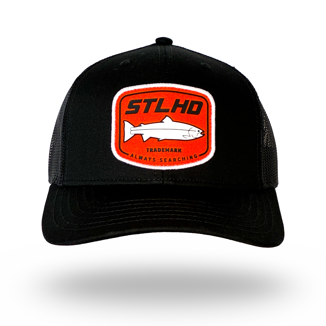 Black STLHD trucker cap with front oval patch logo and orange border
