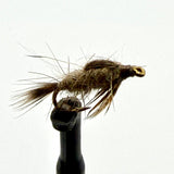 Brown feather fishing fly with gold hook on black holder