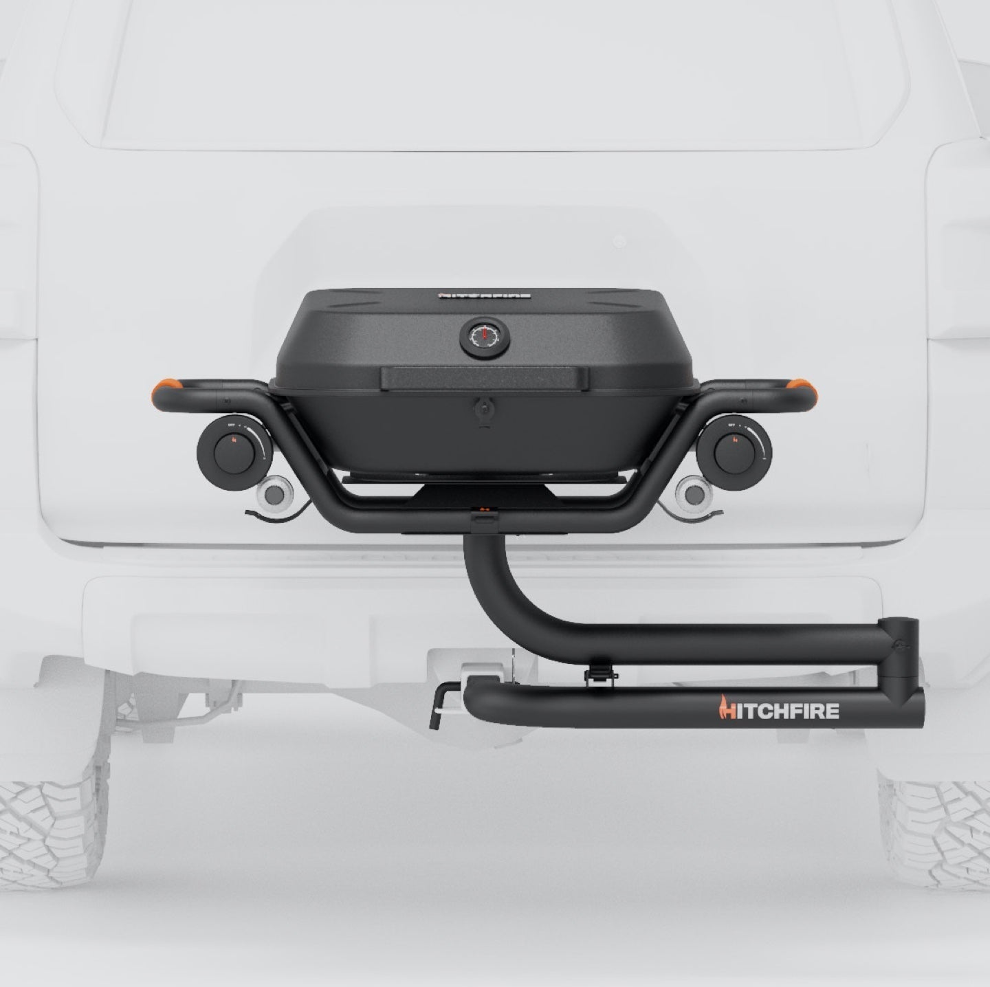 Hitch-mounted propane grill with closed lid and four front control knobs on swing arm