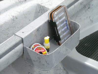 Mounted grey storage tray with open compartments holding small tools and bottle